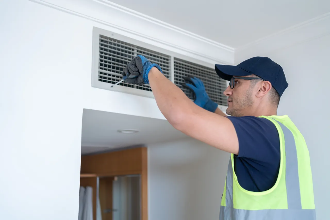 man fixing vent